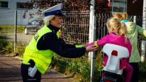 policjanci przy szkole prowadzą akcję profilaktyczną, rozdają odblaski