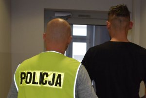 policjant prowadzi zatrzymanego