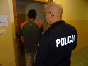 policjant prowadzi zatrzymanego