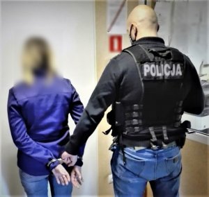 Policjant prowadzi zatrzymanego