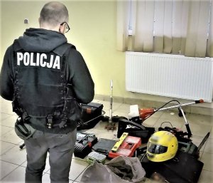 Policjant w trakcie oględzin zabezpieczonych rzeczy