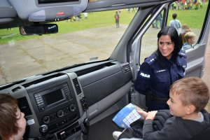 policjanci prezentują sprzęt i rozmawiają z dziećmi na festynie