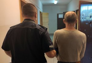 policjant prowadzi zatrzymanego