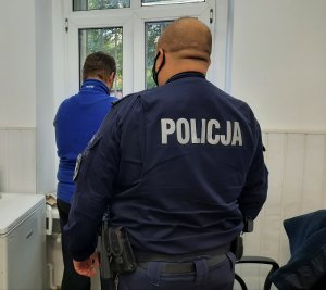 policjant prowadzi zatrzymanego