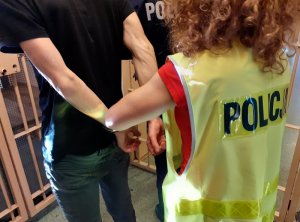 policjantka prowadzi zatrzymanego