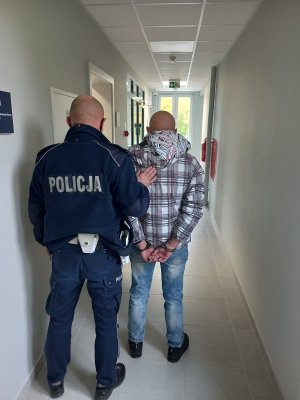 policjant prowadzi zatrzymanego