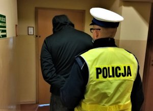 policjant z zatrzymanym mężczyzną, złodziejem sprzętu od koparki