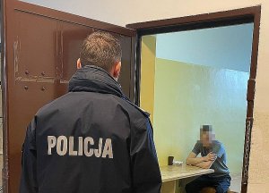 policjant w pomieszczeniu dla osób zatrzymanych