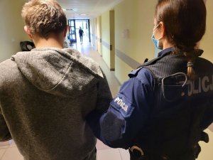 policjantka trzyma zatrzymanego mężczyznę