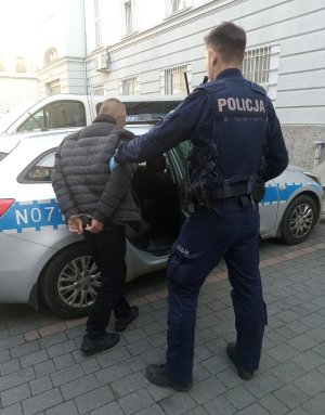 policjant z zatrzymanym za rzucenie kamieniem w autobus