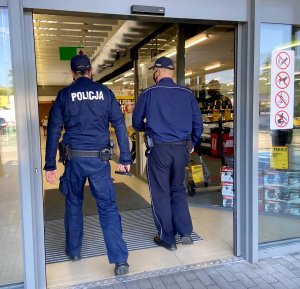 policjanci wchodzący do placówki handlowej na kontrolę