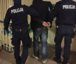 policjanci prowadzą zatrzymanego