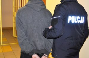 Policjant prowadzi zatrzymanego