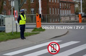 policjant stoi przed przejściem dla pieszych