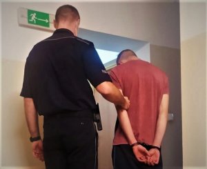 policjant prowadzi zatrzymanego