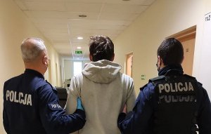 policjanci prowadzą zatrzymanego