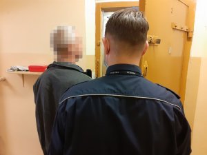 policjanci stoją z zatrzymanymi