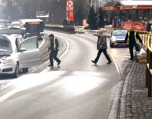 policjanci pomagają ugasić płonące auto