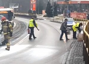 policjanci pomagają ugasić płonące auto