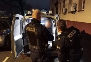 policjanci wprowadzają do radiowozu zatrzymanego mężczyznę