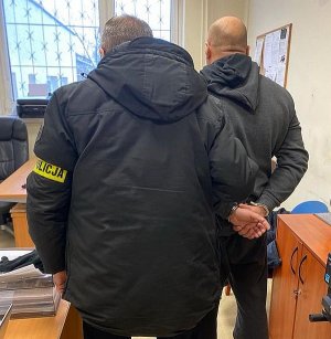 policjant z zatrzymanym mężczyzną