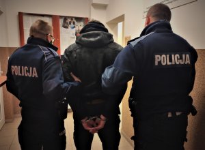 policjanci prowadzą zatrzymanego mężczyznę