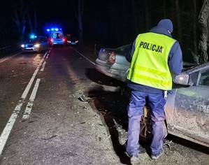 policjant na miejscu wypadku przy rozbitym aucie