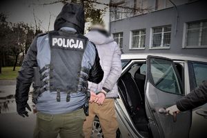 policjant prowadzi zatrzymanego