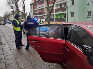 policjanci stoją przy rozbitym samochodzie