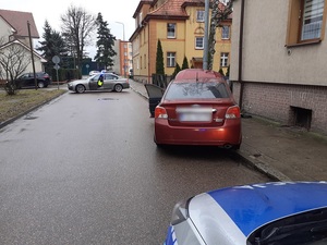 policjanci stoją przy rozbitym samochodzie