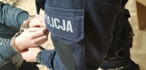 policjantka zakłada kajdanki zatrzymanemu