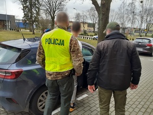 Policjanci prowadzą zatrzymanego