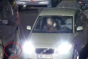 Zdjęcie z monitoringu, na którym widać jak wystają nogi osoby, która wycina katalizator z pojazdu