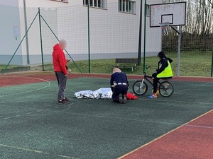 policjantka udziela pomocy chłopcu który zasłabł na boisku