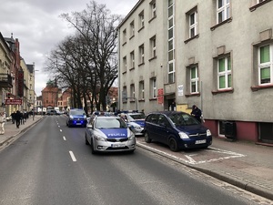 policjanci prowadzą zatrzymanego nożownika