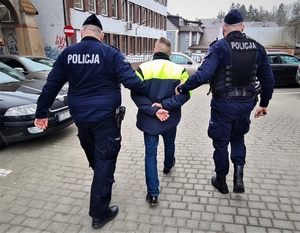 policjanci prowadzą zatrzymanego