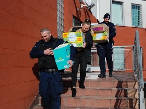 policjanci schodzą ze schodów niosąc zebrane dary