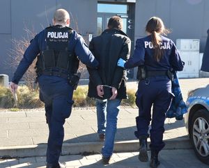 Policjanci prowadzą zatrzymanego