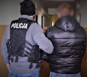 Policjant prowadzi zatrzymanego