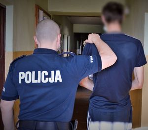 Policjant prowadzi zatrzymanego