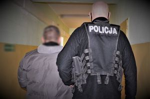 Policjanci prowadzą zatrzymanego