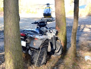 policjanci pracują na miejscu wypadku z udziałem kierowcy quada. Na zdjęciach rozbity quad.