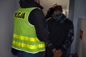 Policjant prowadzi zatrzymanego