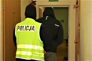 policjant prowadzi zatrzymanego