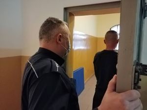 policjant zamyka zatrzymanego mężczyznę