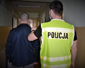 policjant prowadzi zatrzymanego