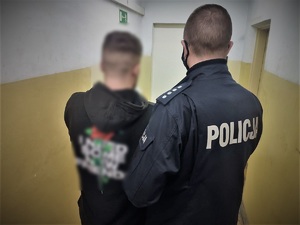 policjant prowadzi zatrzymanego