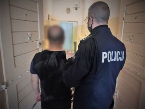 policjant prowadzi zatrzymanego