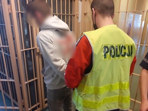 policjant prowadzi zatrzymanego