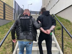 policjant prowadzi zatrzymanego